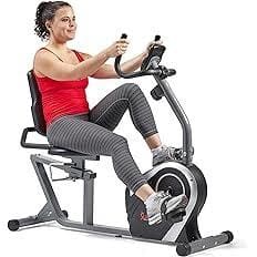 A woman is sitting on the exercise bike
