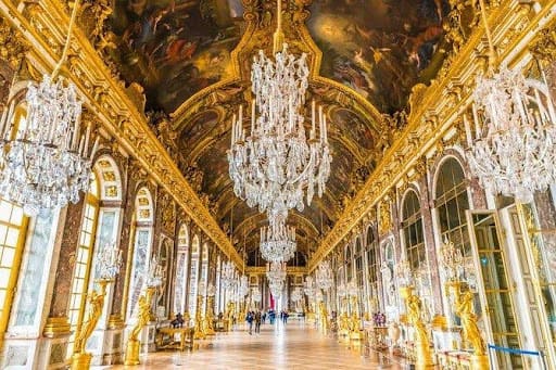 A large room with many chandeliers and gold paint.