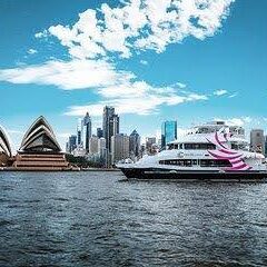 A boat in the water with a city skyline behind it.